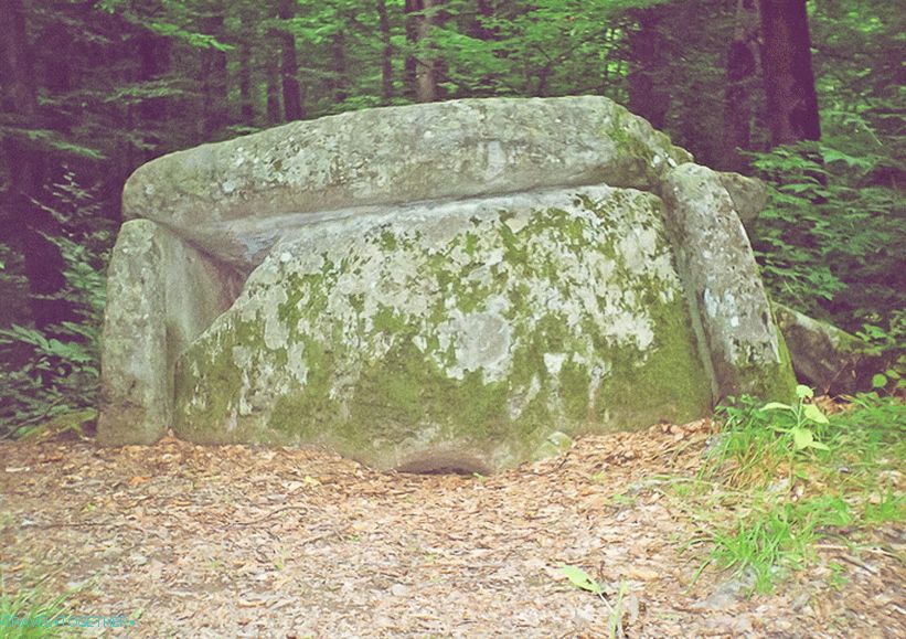 Dolmen, ingrown into the ground and slipping into a precipice
